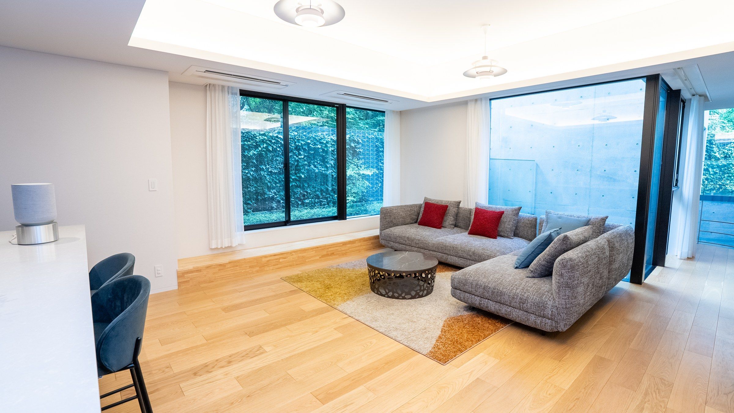 The main living room: cove-lit ceiling, oak floor, the kitchen beyond.